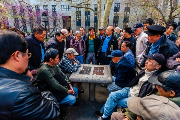 Older Chinese men playing Chinese chess, Columbus Park, Mulberry Street, Chinatown, New York City, New York USA.